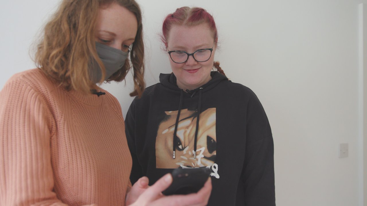 development Coordinator showing learner how to use the AutonoMe app and support.